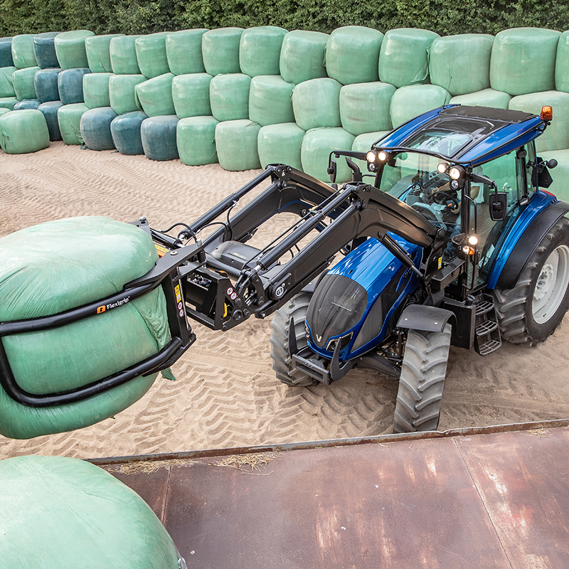 valtra a series tractor on the field with hay bales